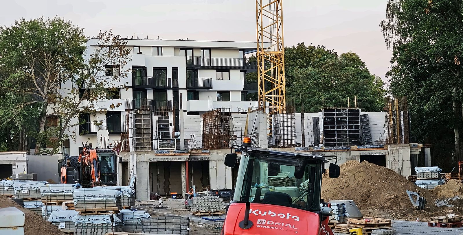 Budowa osiedla Rose Park w Szczecinie – plac budowy, w tle budynek mieszkalny z gotową elewacją